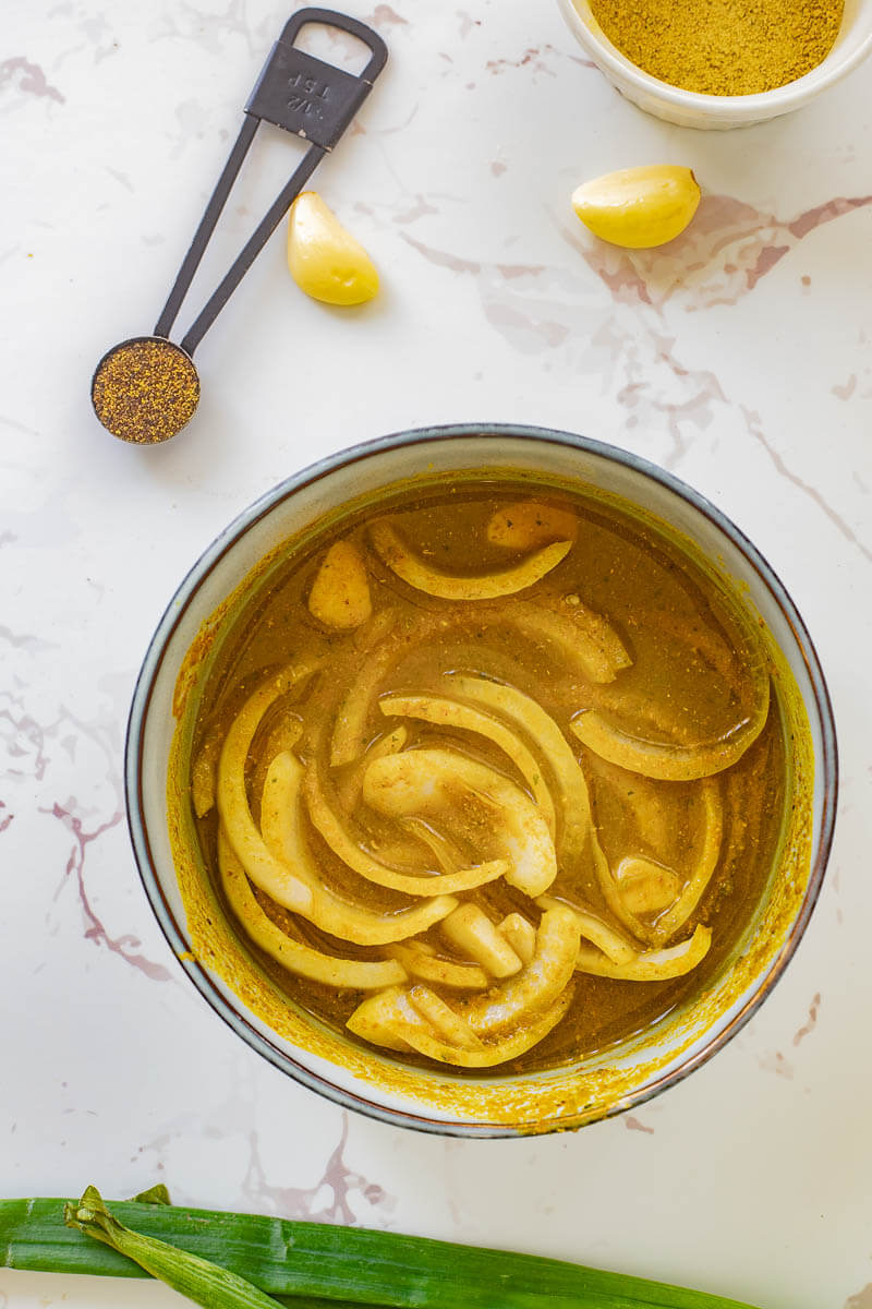 Curry paste mixture of water, green seasoning, curry powder, onions and garlic.