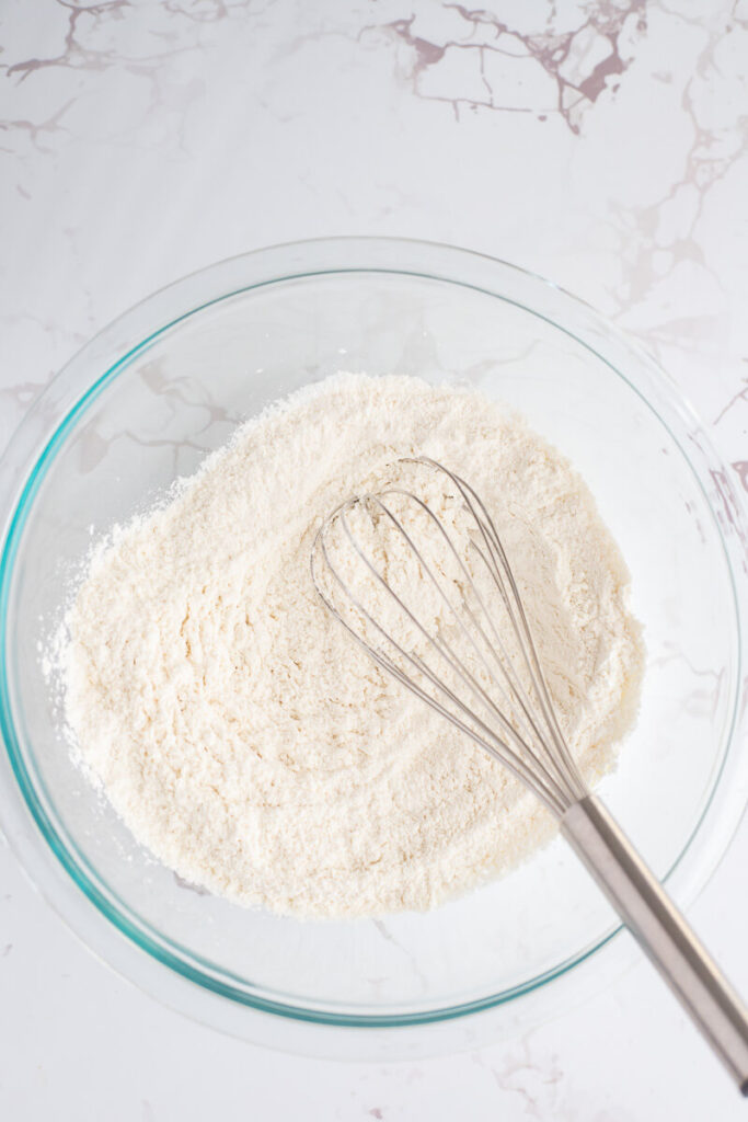 Dry ingredients to make sorrel cake in a bowl with a whisk.