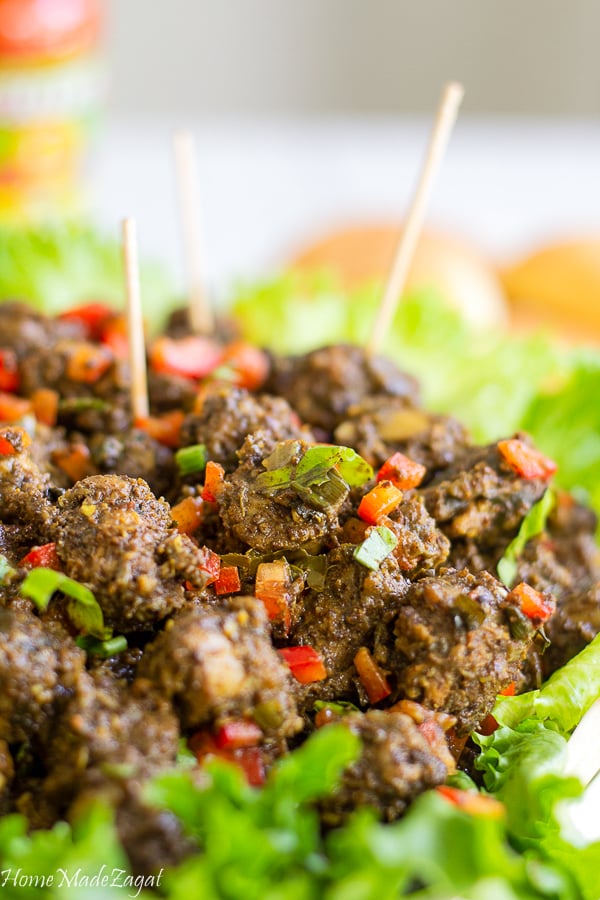 Cooked geera chicken necks with fresh herbs on a bed of lettuce.