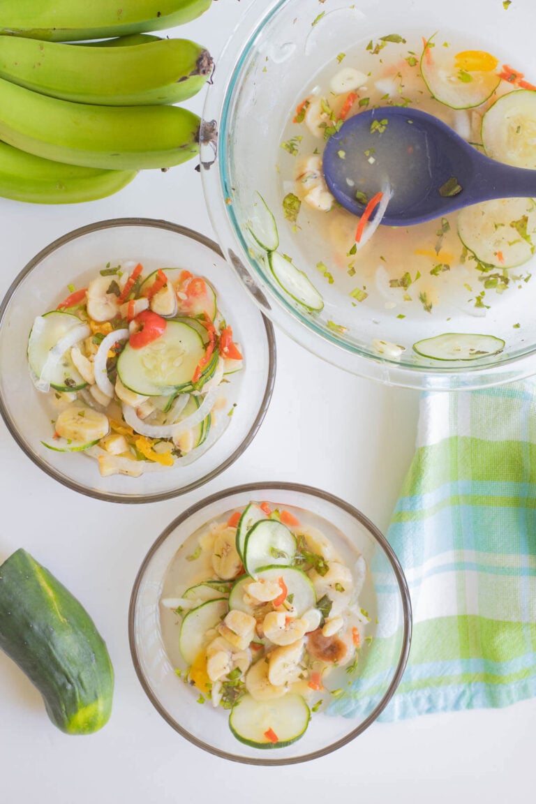 Green fig souse in glass bowls with a hand of green banana and cucumbers.