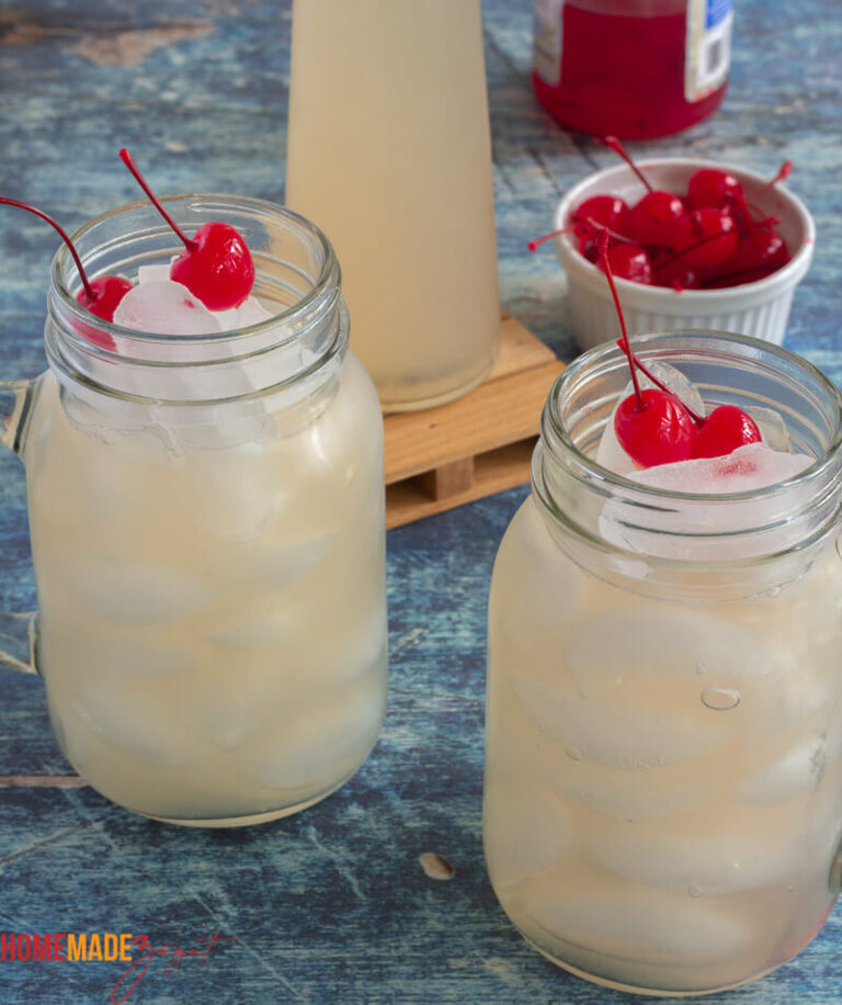 Mason jars packed with ice and guava fruit juice and topped with cherries