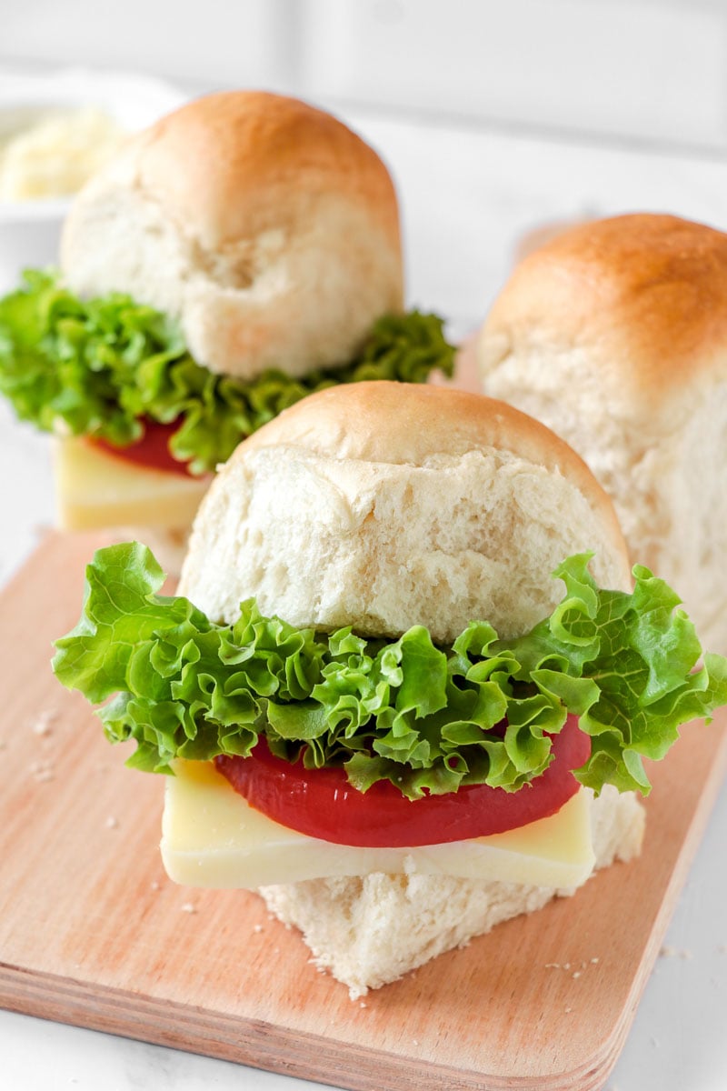 Close up of couple of hops bread with lettuce, cheese and tomato to make a good sandwich.