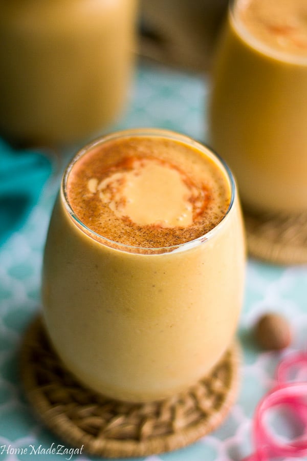 Close up of a shot of pumpkin punch, with cinnamon dusting the top.