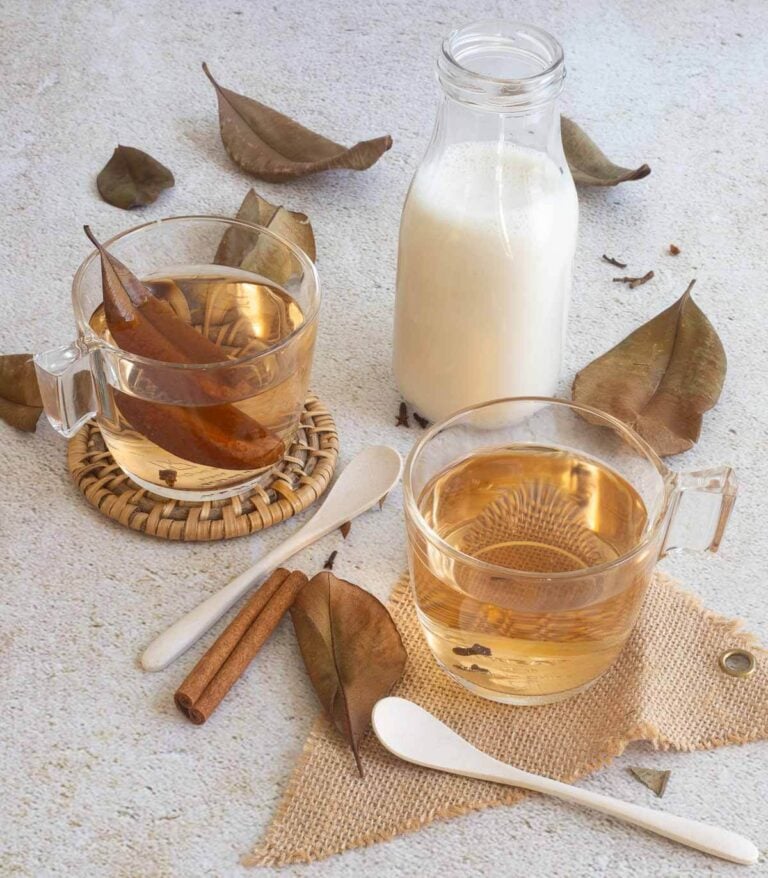 Deliciously brewed bay leaf tea in a glass cup with cloves and cinnamon.