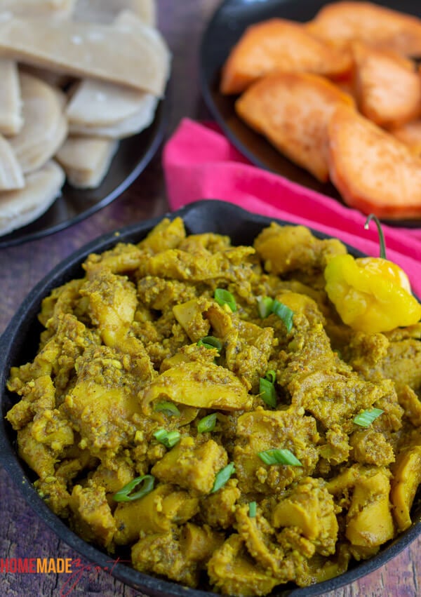 A pot of curried conch along with a plate of boiled dumplings and provisions