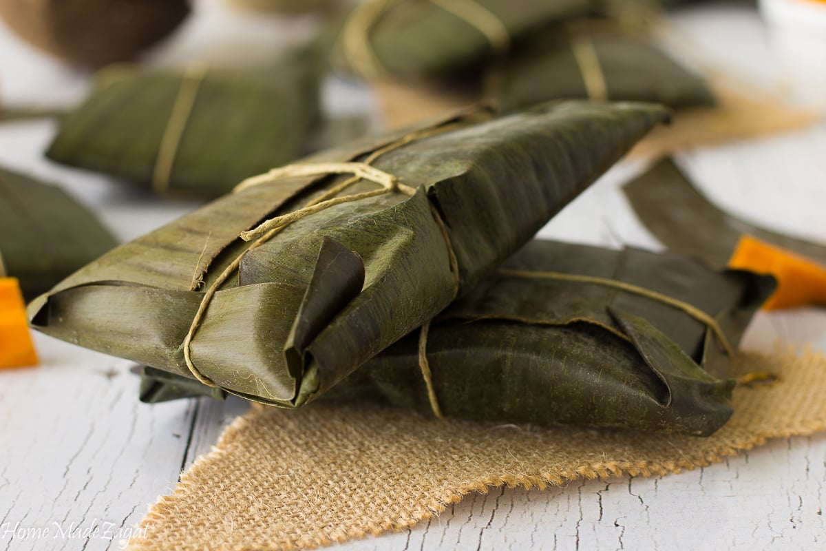 a close up of a wrapped paime in banana leaf.