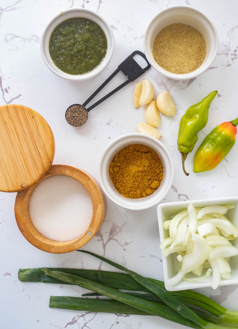 Spices and herbs needed to make curry stew chicken portioned out.