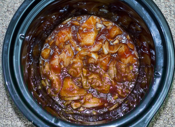 Chicken in the slow cooker covered in jerk bbq sauce ready to be cooked.