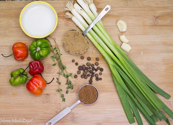 Ingredients to make the jerk marinade on top a wooden board.