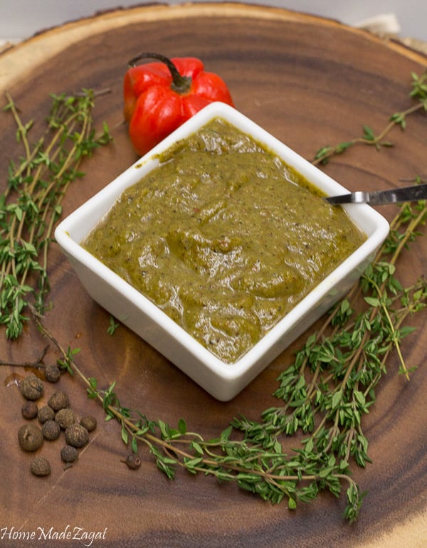 This is a picture of a white dish full of jerk marinade with fresh thyme around it