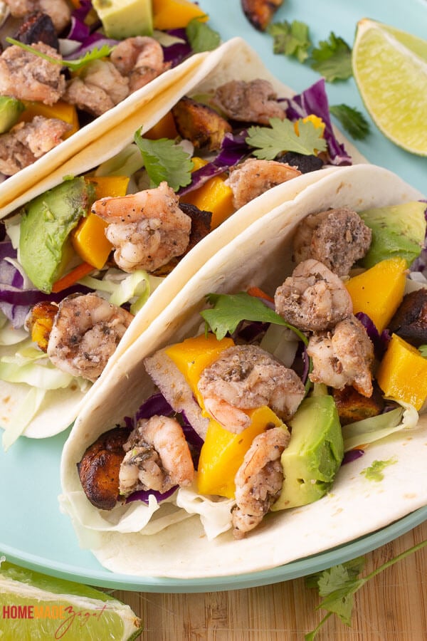 Delicious tacos with jerk shrimp and cabbage slaw with ripe plantains and mango salsa.