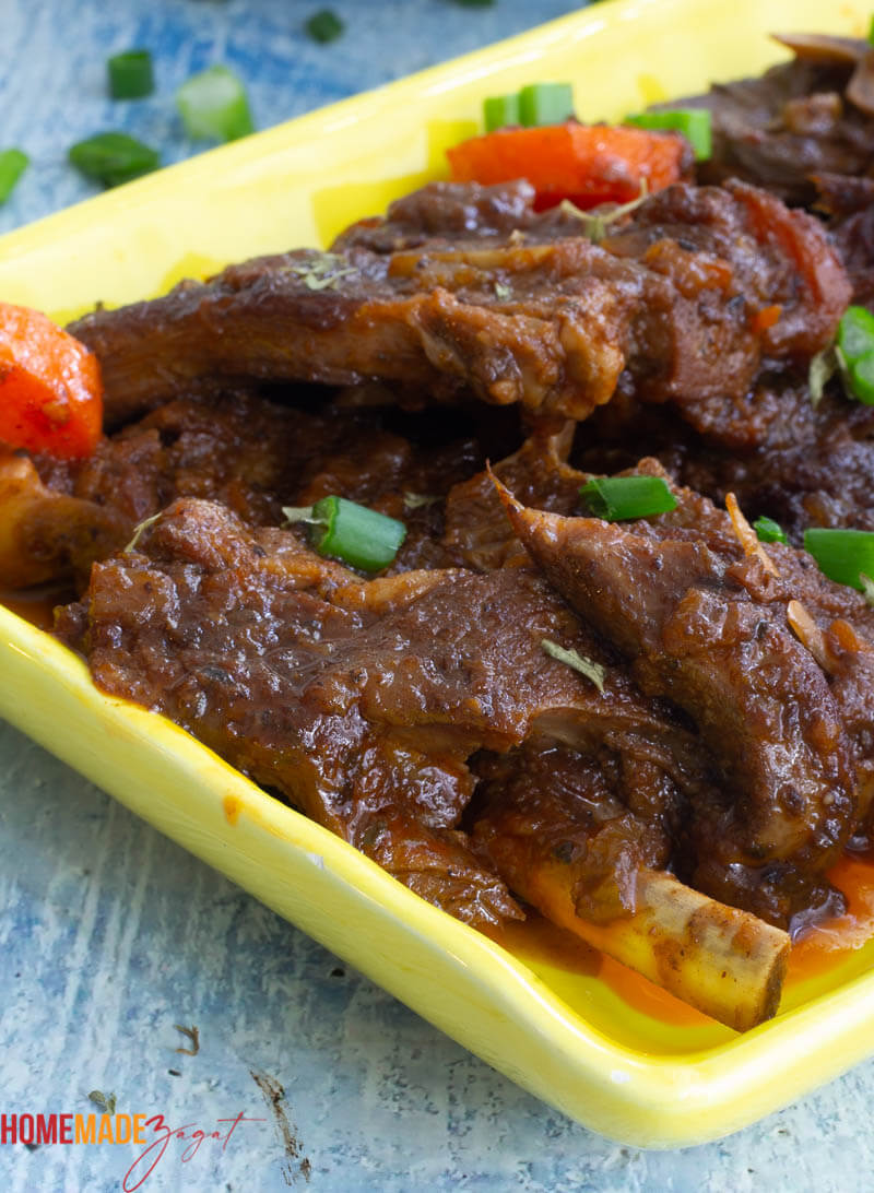 Slices of cooked lamb stew on a yellow plate