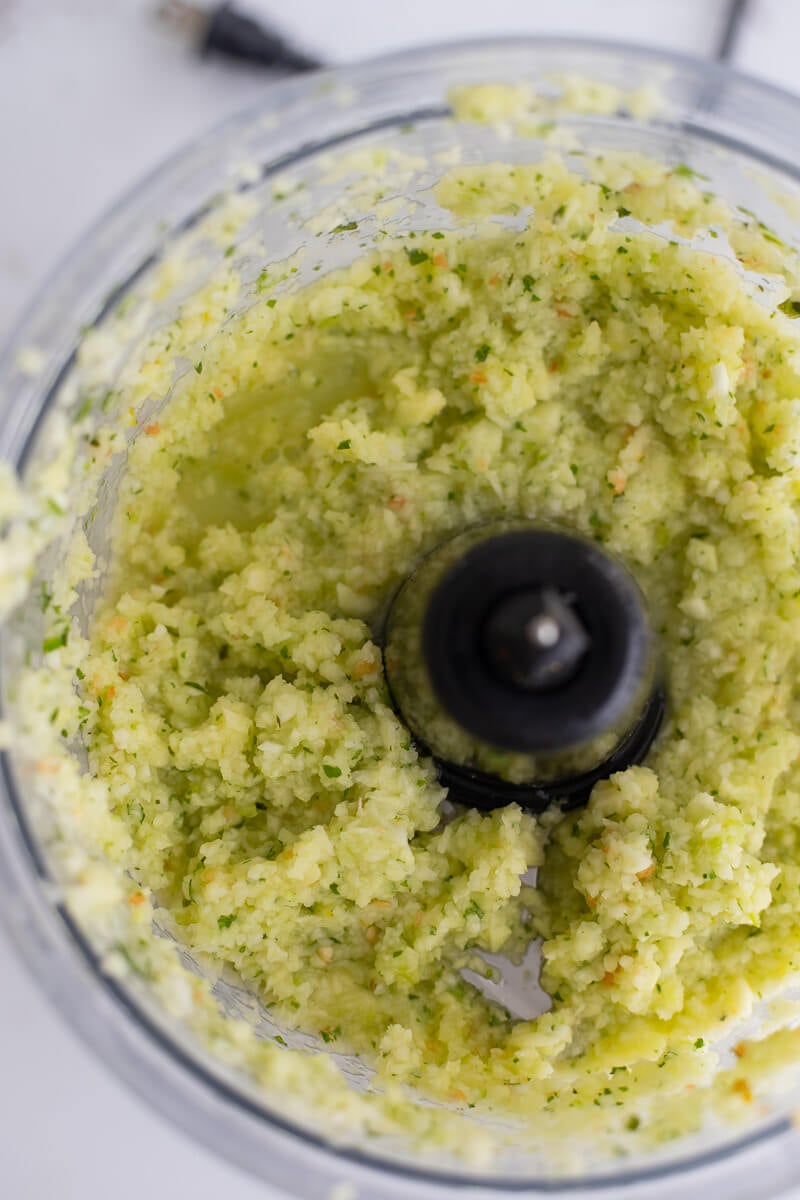 Grinded up mango and fresh herbs in the food processor.