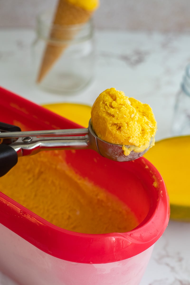 A close up of a scoop of homemade mango ice cream.