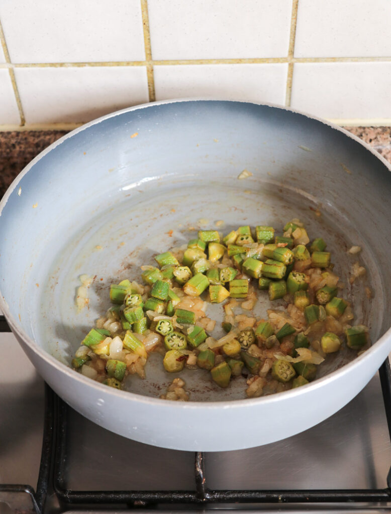 Onions, garlic and ochros being sauted in hot oil to remove the slime from the ochro.