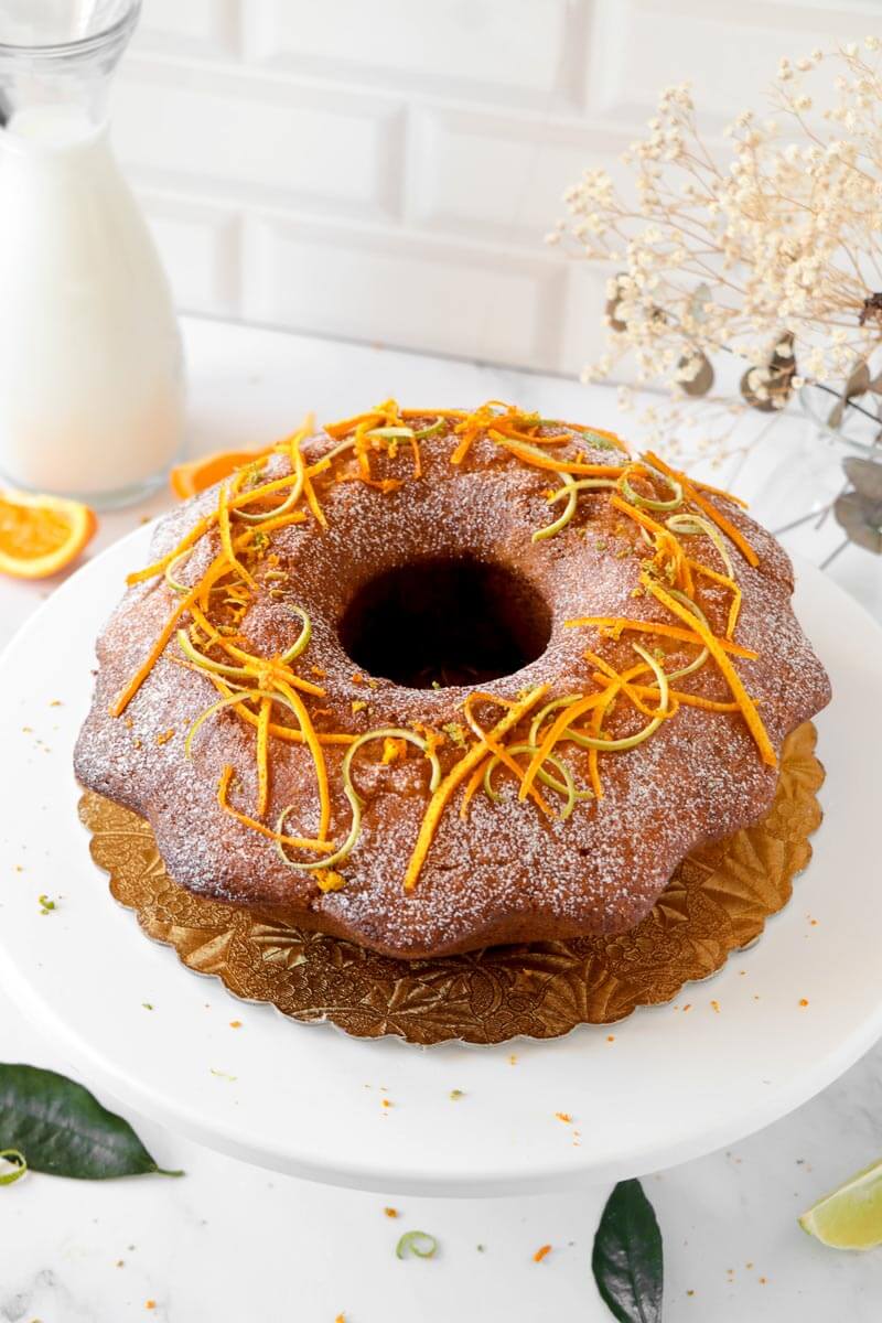 Completed citrus rum cake with powdered sugar and citrus rind.