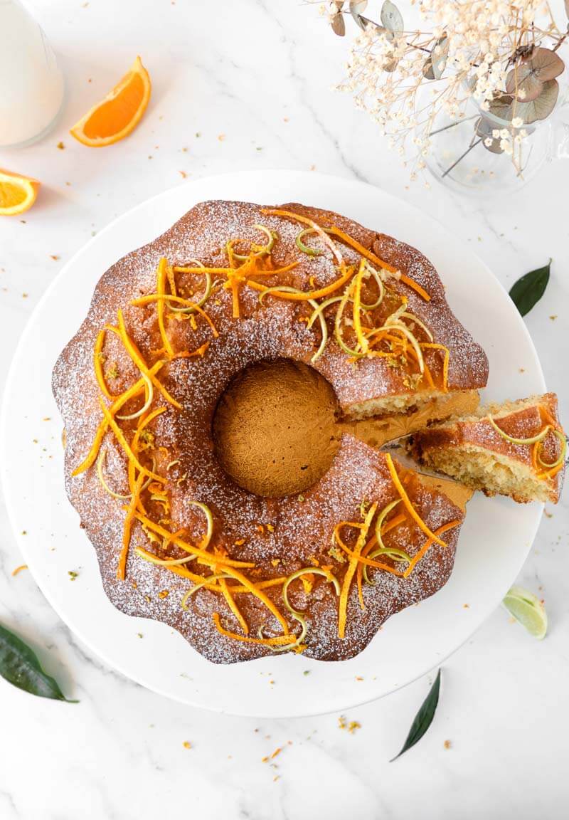 Completed citrus rum cake with powdered sugar and citrus rind.