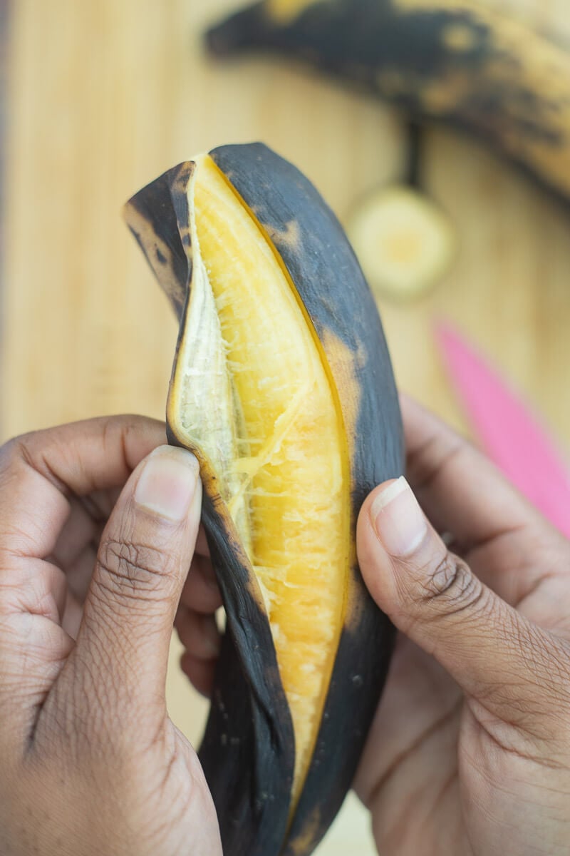 A ripe plantain being peeled open.