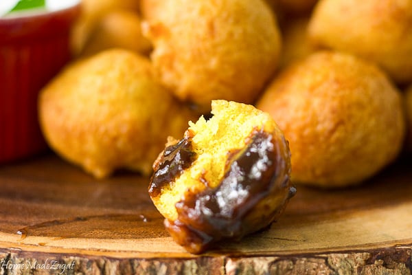 One ball of pholourie with some tamarind dipping sauce on it