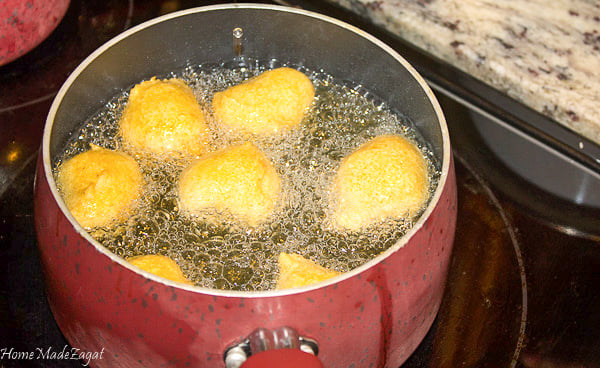 A pot of oil with pholourie frying in it