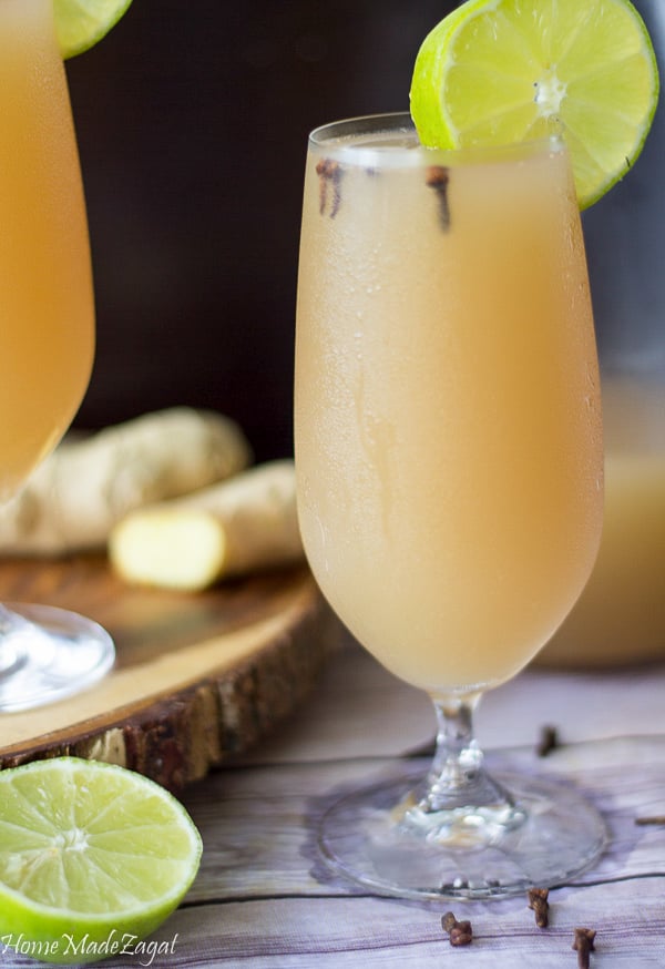 A single glass of Caribbean ginger beer. Chilled and with some lime wedges