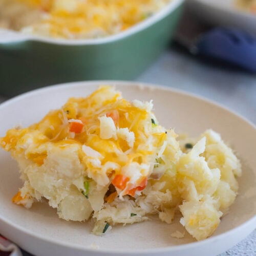 A slice of cassava and fish pie in a creamy bowl.