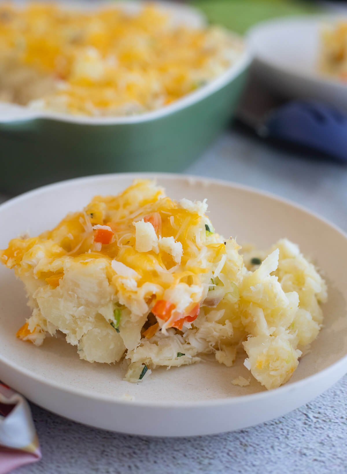 A slice of cassava and fish pie in a creamy bowl.