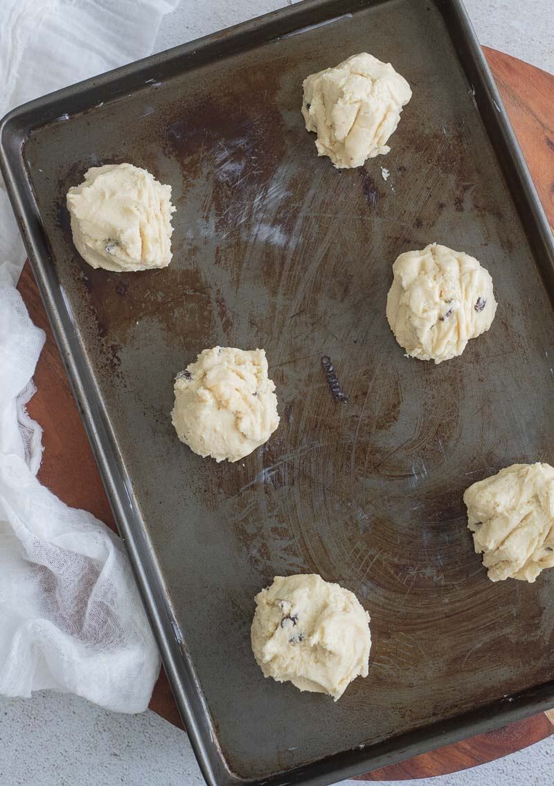 Portioned out rock buns on the greased baking sheet.