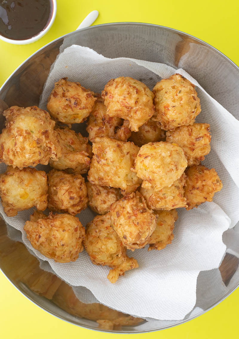 A bowl of saltfish friitters on paper towel.