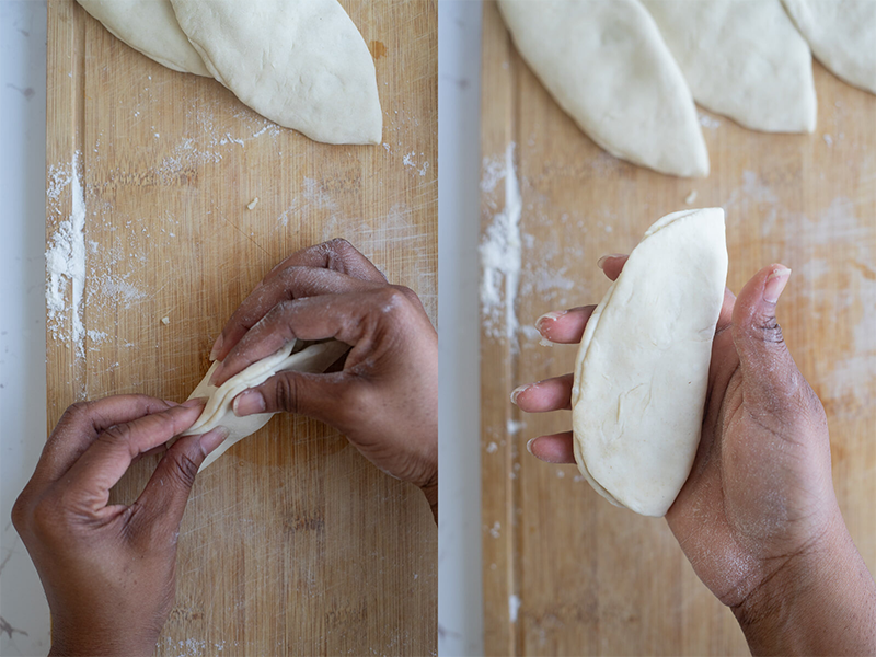 Step of sealing an aloo pie closed over a wooden cutting board.