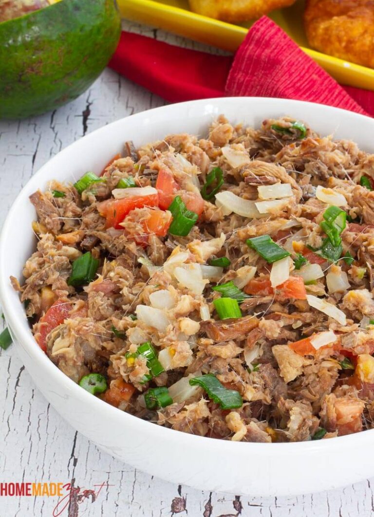 A bowl of cooked smoked herring with tomatoes, onions and scallion