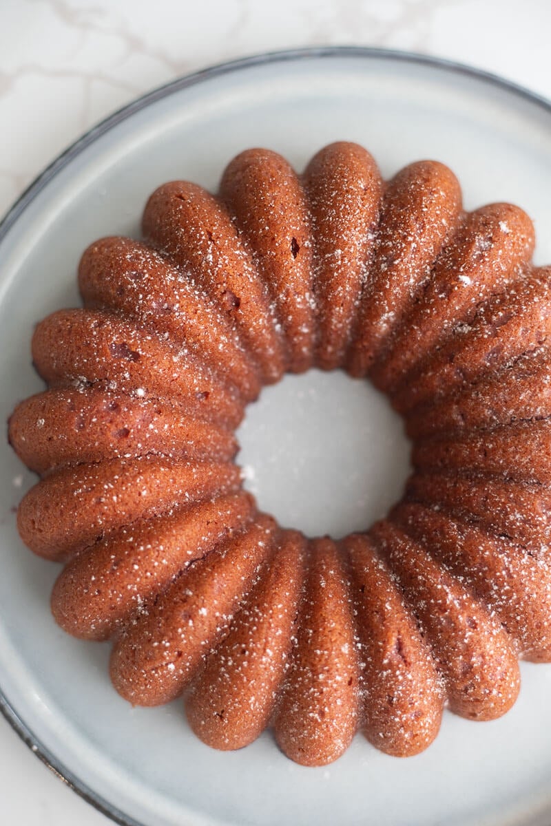 Finished baked sorrel cake on light blue plate sprinkled with powdered sugar.