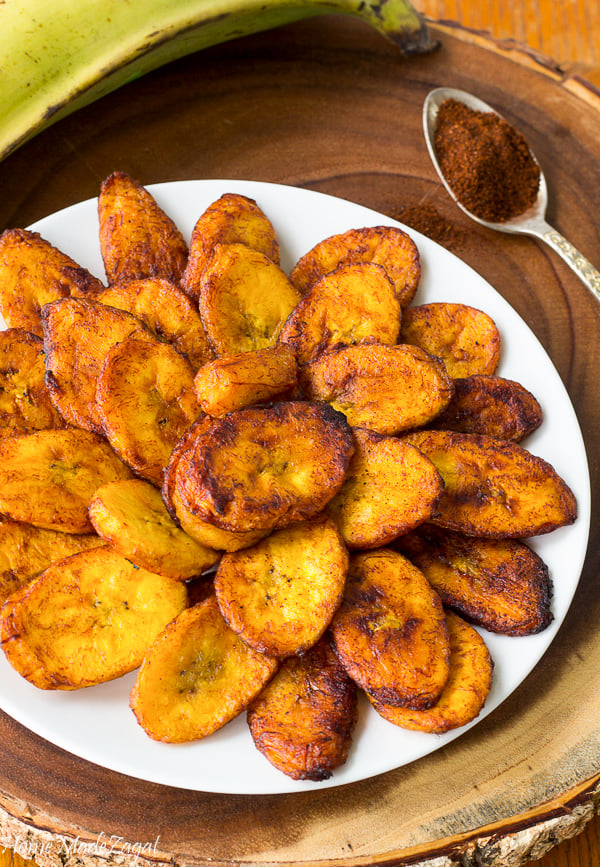 Sliced ripe plantains, fried to golden brown on a plate.