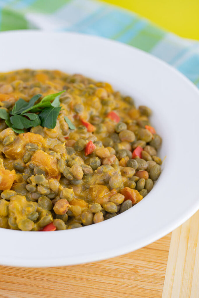 Stewed pigeon peas in a serving bowl with visible herbs and gravy.