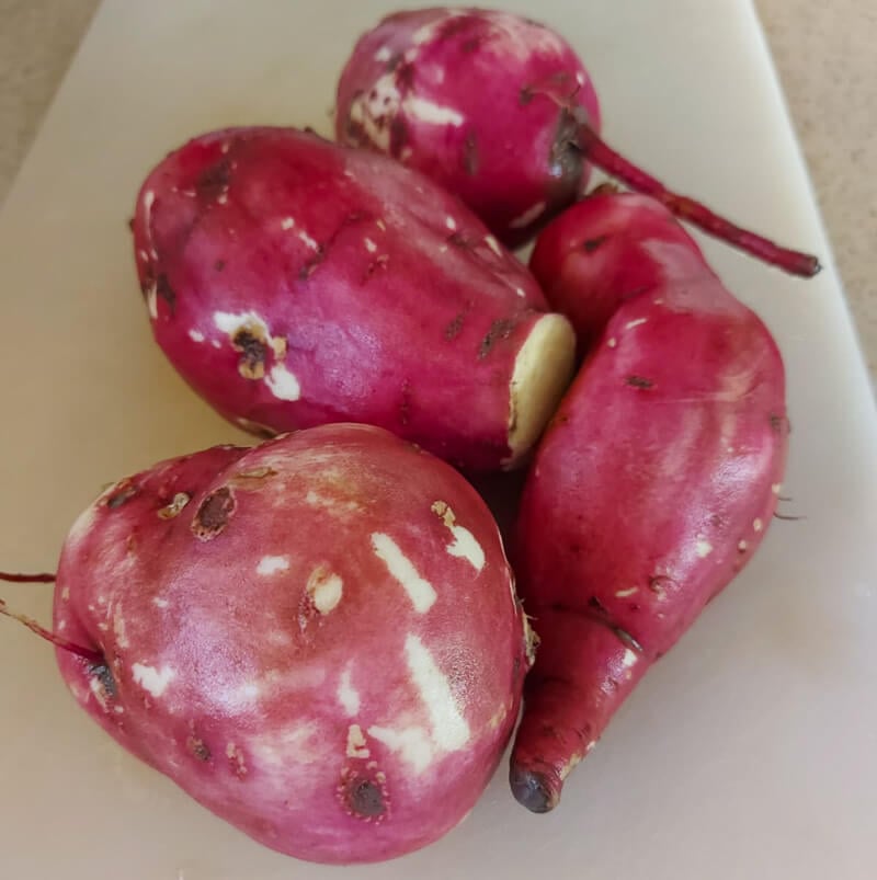 A group of Caribbean sweet potatoes on a white board.