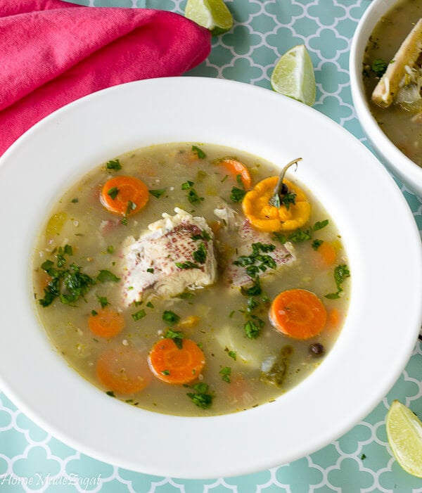 Finished fish broth served to eat with lime slices.