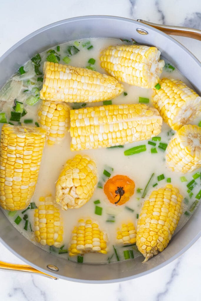 Corn ready to be boiled in coconut milk with fresh herbs.