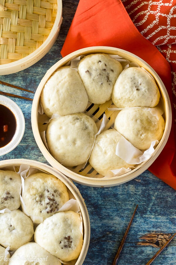 Steamed pows in a basket at a top down view.