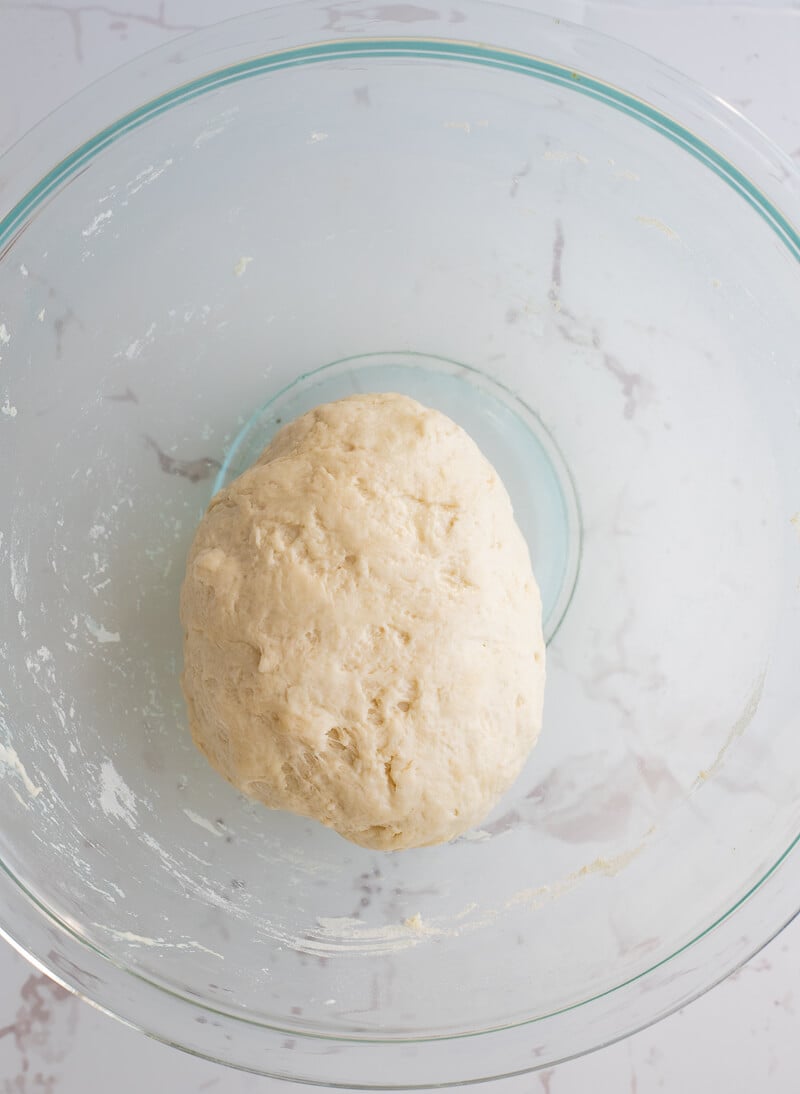 A ball of the mixed dough in a glass bowl used to make aloo Trinidad aloo pie.