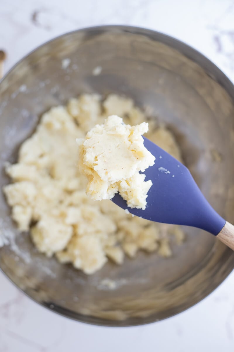 A silver bowl of seasoned up potatoes to be used as filler for Trinidad aloo pies.