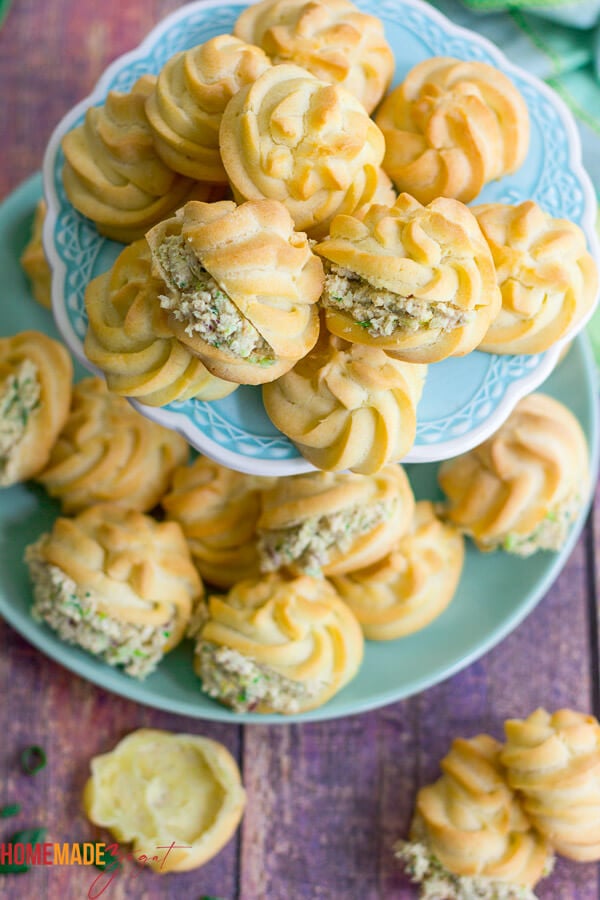 A platter of filled chicken puffs on a blue cake stand.