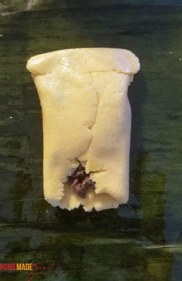 Pastelle dough on a banana leaf with sides folded in