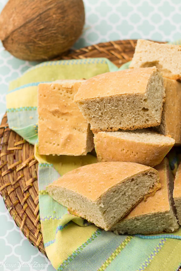 Coconut bake (roast bake), cut up into slices and served on a brown serving board.