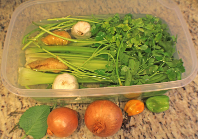Ingredients for green seasoning layed out on a table.