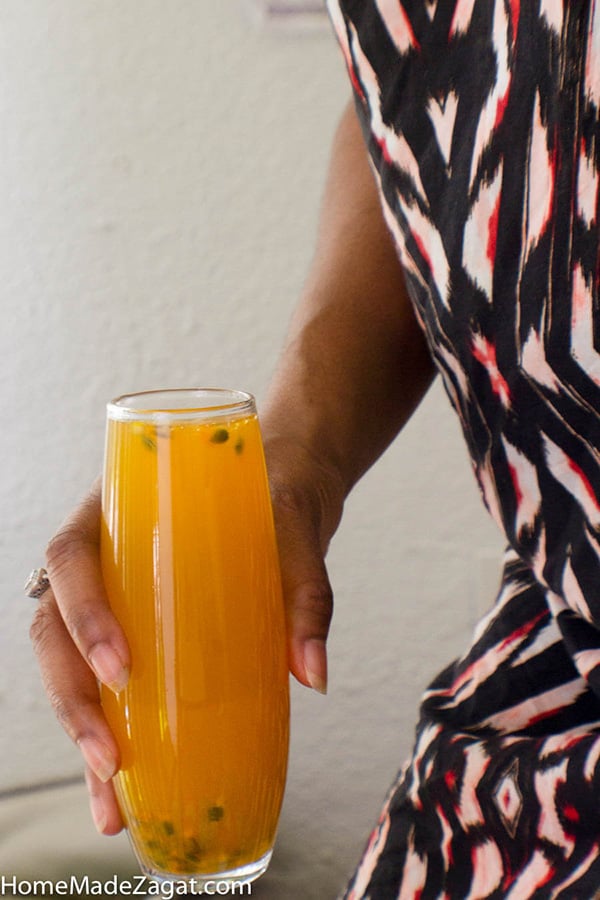 A picture of me holding a glass of mango passion fruit juice.