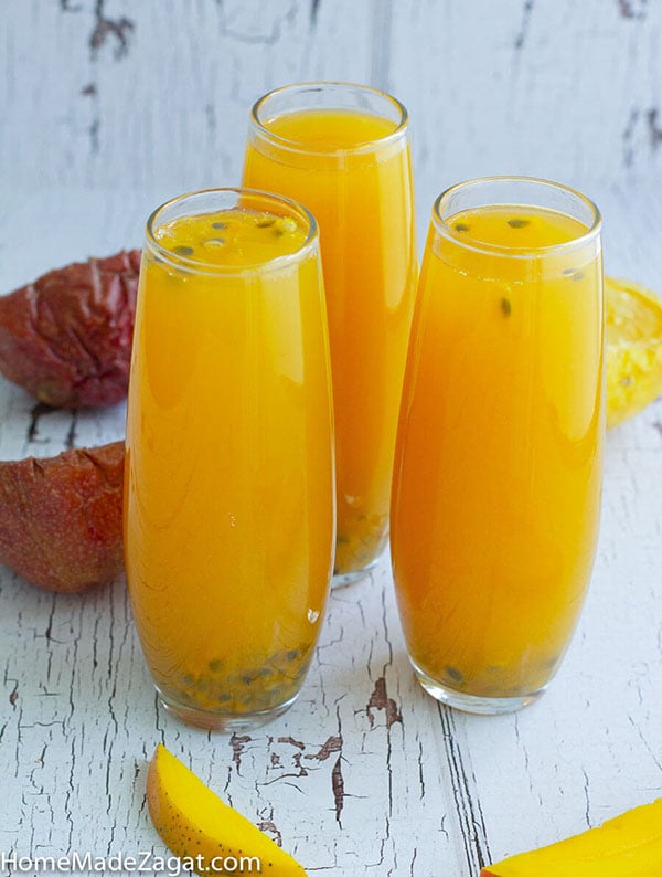 Three glasses of mango passion fruit juice on a white background.