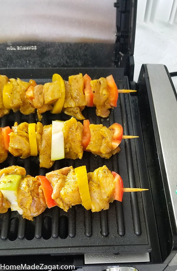 Spicy chicken kebabs on electric grill being cooked