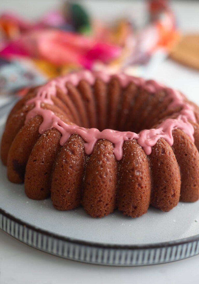 Sorrel cake with sorrel glaze on a light blue plate with a patterned napkin in the background.