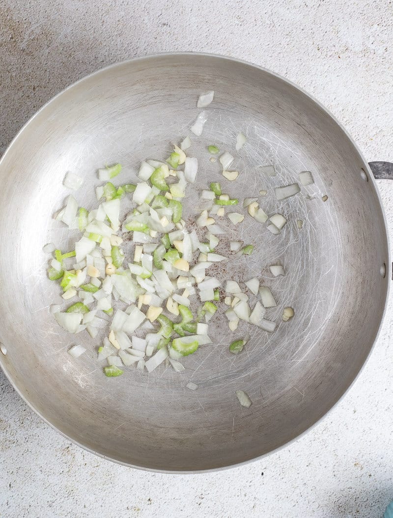 Onion and garlic being sautéed in oil.