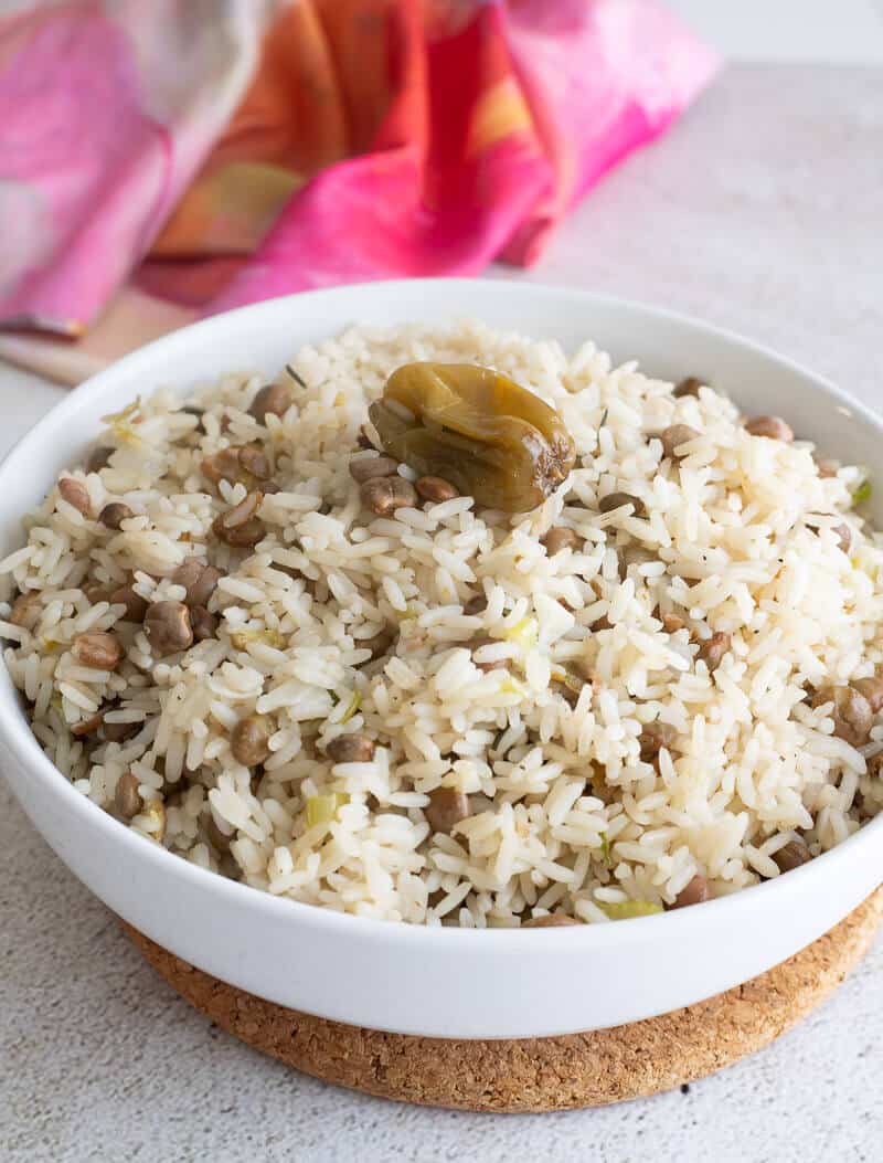 Finished bowl of rice with pigeon peas on a brown coaster.